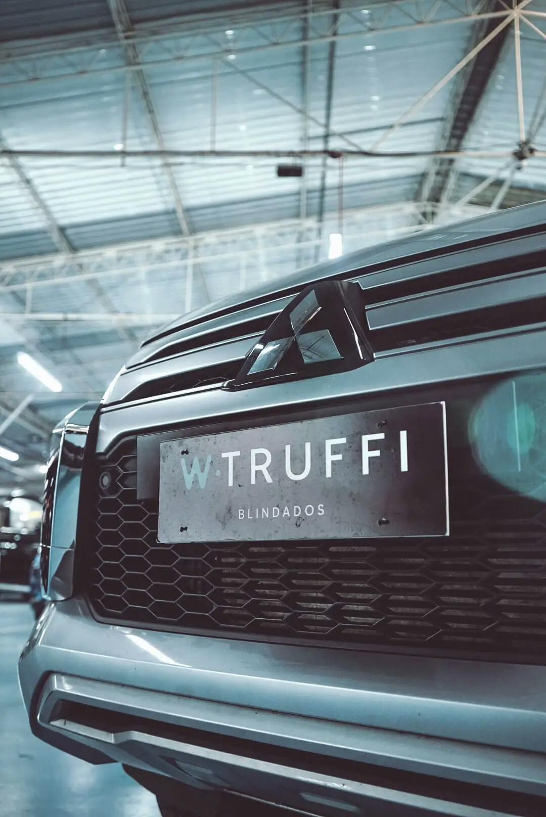 Foto de perto de um carro da Mitsubishi com uma placa da W. Truffi blindados